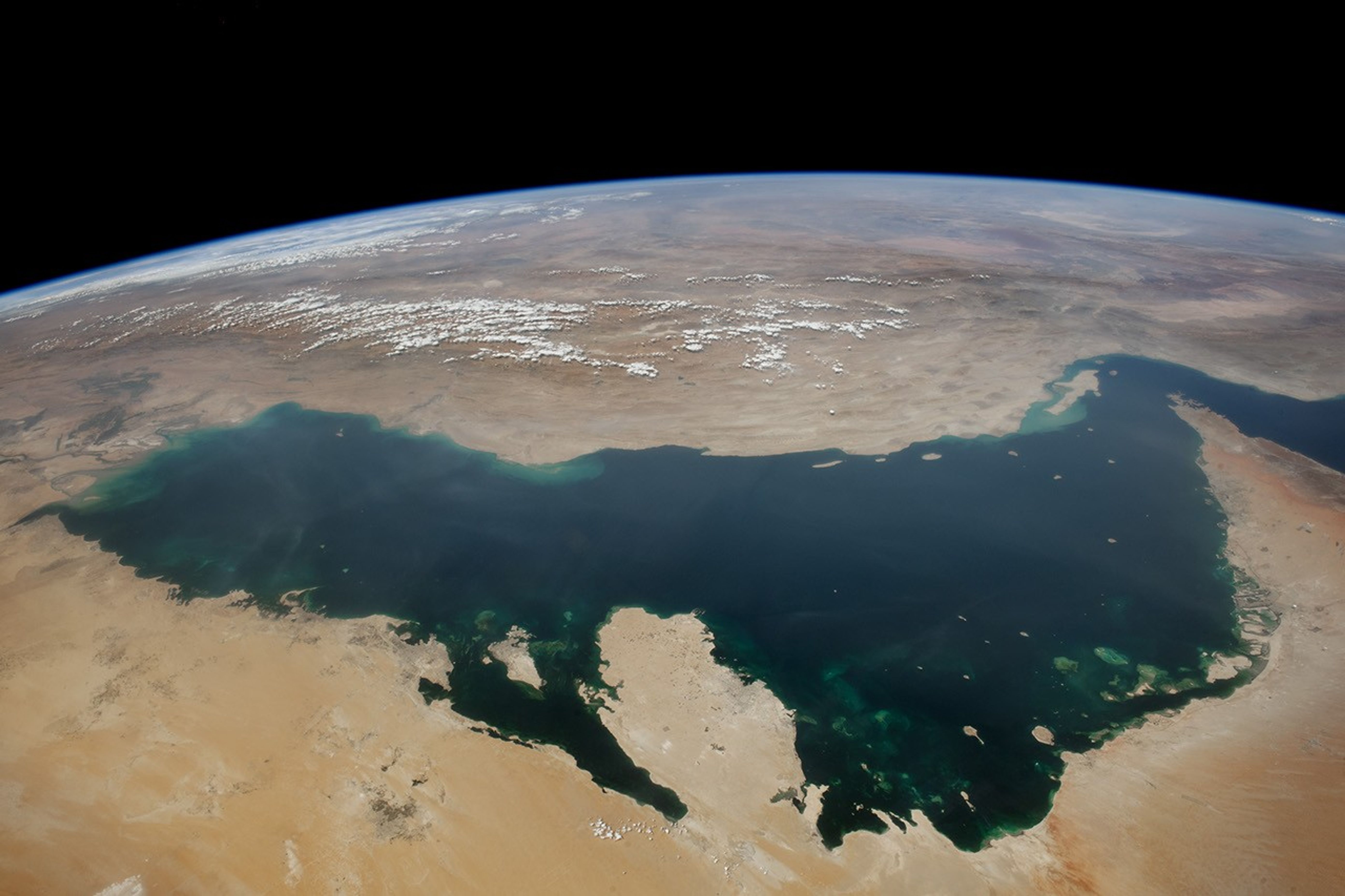 A real photograph of the Gulf from the International Space Station, with a navy and teal colour treatment.